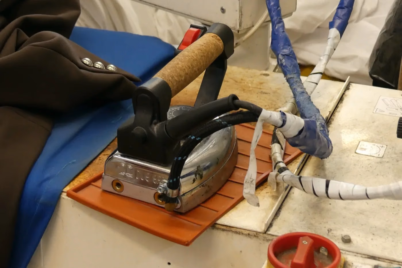 Fer à repasser professionnel à vapeur sur la table de repassage de l'atelier